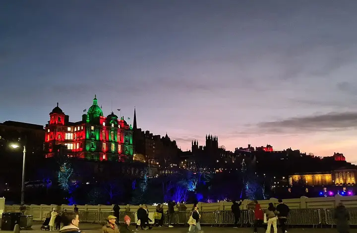 Illuminated Edinburgh buildings and skyline at dusk.