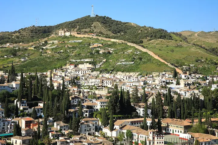 White hillside buildings and greenery in Granada.