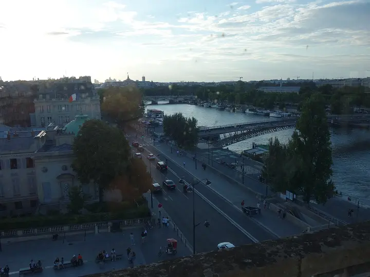 River, roads and rooftops in Paris at sunset.
