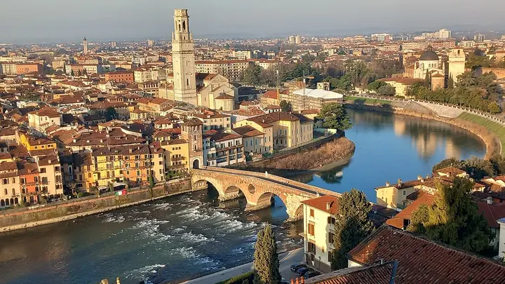 Red rooftops, a stone bridge and the river winding through Verona.
